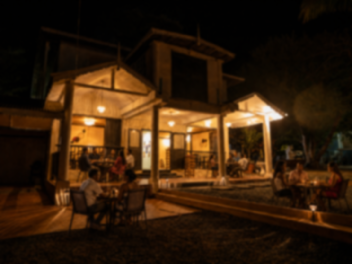The warmly lit exterior dining area of Monty's Restaurant & Cocktail Bar in Tobago at night